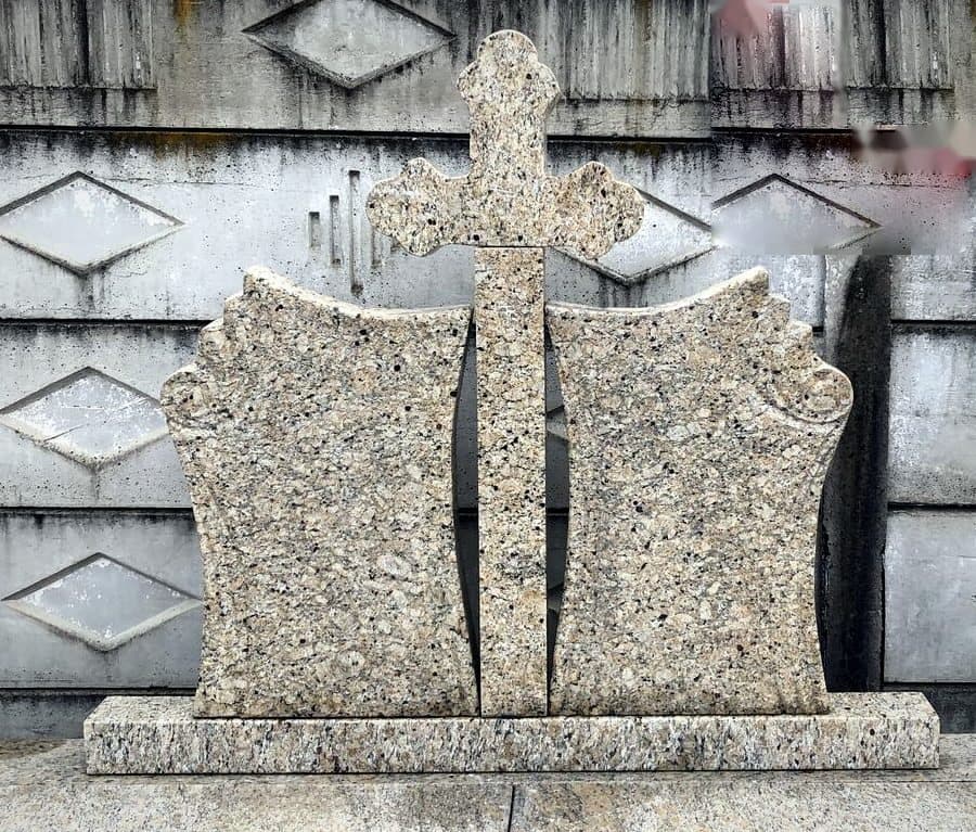 Cruce funerară dublă din granit bej cu cărți sculptate și cruce centrală, în atelierul Mogut.