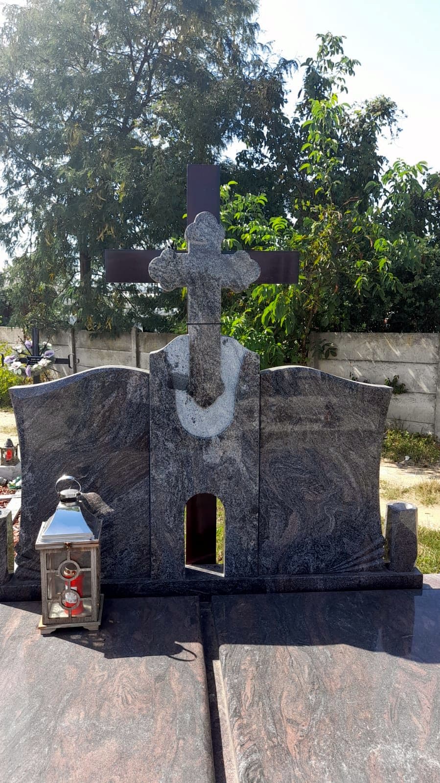 Monument funerar dublu din granit gri multicolor, cu cruce neagră și giulgiu sculptat