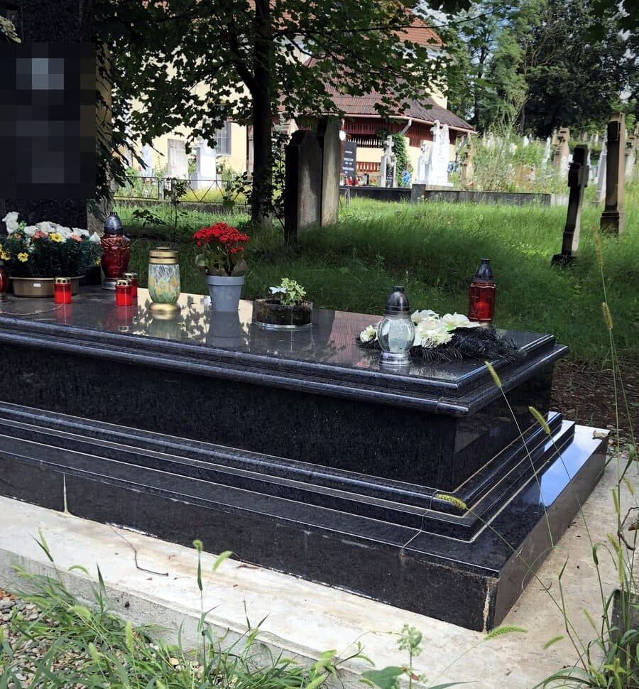 Monument funerar simplu din granit negru lustruit, montat în cimitir.